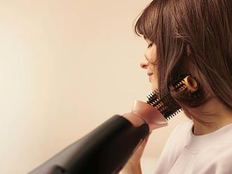 photo of woman blow drying her hair with a panasonic product